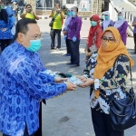 Kepala Dinas Kesehatan (Dinkes) Kota Kediri, dr. Fauzan Adima saat menyerahkan masker secara simbolis kepada tenaga kesehatan yang bertugas membagikan masker kepada masyarakat. foto: MUJI HARJITA/ BANGSAONLINE