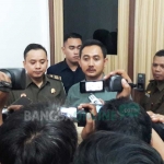 Kasi Intel Kejari Gresik R. Bayu Prabo Sutopo didampingi Kasi Pidsus Andre Dwi Subianto memberikan keterangan pers usai OTT pejabat BPPKAD Gresik. foto: SYUHUD/ BANGSAONLINE