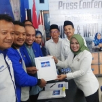 Kartika Hidayati saat menyerahkan formulir pendaftaran kepada Ketua DPC PD Lamongan Deby Kurniawan.
