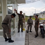 Petugas Dispol PP ketika menyegel perumahan PT. Patra Raya Cerme. foto: SYUHUD  A/ BANGSAONLINE
