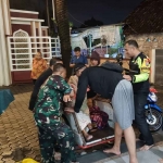 Warga terdampak banjir saat dibantu petugas dari Polres Mojokerto Kota.