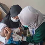 Tenaga kesehatan dari Rutan Perempuan Surabaya saat memberikan imunisasi kepada bayi warga binaan.