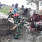 Anggota TNI Koramil Bluluk bersama masyarakat membangun jalan desa.