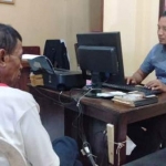 Tersangka Sukirman sedang diperiksa petugas di Polsek Ambulu Jember.