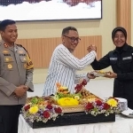 
Ketua PWI Kediri Bambang Iswahjoedhi saat menyerahkan potongan tumpeng kepada Kasi Humas AKP Sriati disaksikan oleh Kapolres Kediri AKBP Bimo Ariyanto. Foto: Muji Harjita/BANGSAONLINE.com