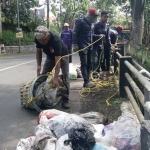 Anggota RCL Kota Batu mengangkat sampah bekas popok bayi dari Kali Oro-oro Ombo Kota Batu.