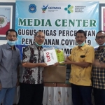 Kacung Purwanto saat menyerahkan bantuan APD kepada dr Taufik Hidayat, Jubir Gugus Tugas Penanganan Covid-19 Lamongan.