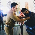 Bupati Pamekasan Baddrut Tamam saat menyerahkan penyematan ID Card kepada petugas sensus penduduk di Pendopo Mandhapa Agung Ronggosukowati Pamekasan.