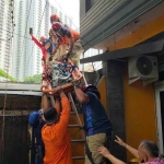 Proses evakuasi nenek mantan atlet panjat tebing oleh BPBD dan Damkar Surabaya dari atap rumahnya.