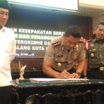 Kapolres Makota disaksikan Pjs Wali Kota Malang bersama pimpinan Forkopimda, saat menandatangani kesepakatan bersama anti atau tolak radikalisme maupun terorisme, di ruang sidang Balaikota, Rabu (30/05). Foto: IWAN I/BANGSAONLINE