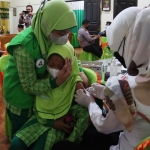 Pelajar MI Ismailiyah Paradigma Baru Kota Mojokerto saling menguatkan saat disuntik vaksin.