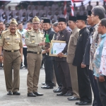 Gubernur Jawa Timur Soekarwo dampingi Menteri Ketenagakerjaan Hanif Dhakiri, saat memberikan penghargaan kepada 10 bupati/wali kota pada acara Bulan K3 di Gedung Negara Grahadi, Jumat (12/1). Foto: IST 