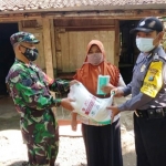 Babinsa Koramil bersama Bhabinkamtibmas Polsek Widodaren saat menyalurkan bantuan sembako kepada warga.
