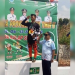 Oqik saat menyanyikan lagu kebangsaan Indonesia Raya usai menerima medali emas dalam cabang Downhill. foto: ist