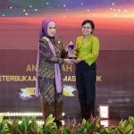 Senior Manager of External Communication SIG, Novi Maryanti (kanan) menerima trofi Predikat Informatif dari Komisioner Bidang Advokasi, Sosialisasi, dan Edukasi KIP, Samrotunnajah Ismail. foto: ist.