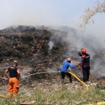 Damkar sedang berupaya memadamkan api kebakaran dari tumpukan sampah yang ada di TPA Pakusari, Kabupaten Jember.