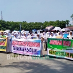 Ratusan warga Thoriqoh Shiddiqiyyah membawa berbagai spanduk saat demo di Alun-Alun Jombang. foto: AAN AMRULLOH/ BANGSAONLINE