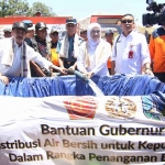 Gubernur Khofifah saat menyalurkan air bersih untuk masyarakat.