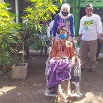 PEDULI: Asrilia Kurniawati Bambang Haryo menyerahkan bantuan kursi roda ke Murti, warga Desa Jiken, Tulangan yang lumpuh, Minggu (9/8). foto: istimewa