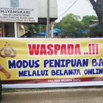 Petugas polisi memasang spanduk peringatan di depan Mapolsek Muara Satu Lhokseumawe, Aceh, Jumat (20/4/2017) agar masyarakat hati-hati, tidak tertipu belanja online. Karena Mapolsek Lhokseumawe  mengaku mendapat banyak sekali pengaduan dari masyarakat. Foto: ist