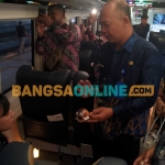 Kadisbudpar Magetan, Joko Trihono  saat bagikan kue khas Magetan kepada penumpang KA. Foto: Hendro Suhartono/BANGSAONLINE