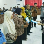 Kepala Dinas Perpustakaan dan Kearsipan Dewi Sartika saat menyerahkan aplikasi e-Pusda kepada perwakilan lembaga sekolah.