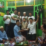 Pendiri RGS Indonesia Moh Khozin menyaksikan Ketua Umum Taufiq Muhammad menerima potongan tumpeng dari Pembina Muslih Hasyim. Foto: SYUHUD/ BANGSAONLINE