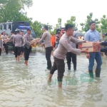 Anggota Polres Ngawi bahu membahu menyalurkan bantuan untuk korban banjir.