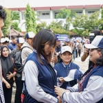 Pj Wali Kota Kediri, Zanariah, saat memakaikan jaket dan topi secara simbolis kepada perwakilan mahasiswa. Foto: Ist