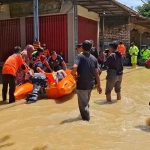 Petugas saat menyisir banjir di Kecamatan Blega, Bangkalan.