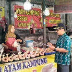 Petugas saat mengecek harga di salah satu stan penjual daging ayam. (Ist)