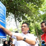 Pemasangan dilakukan melalui metode foto langsung di lokasi, kemudian dicetak, dan ditempel pada rambu kawasan parkir digital. Foto: Hms