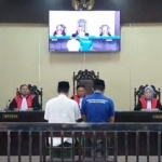 Kedua terdakwa kasus penganiayaan guru saat mengikuti sidang di PN Sampang