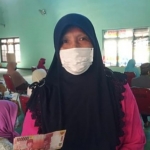 Nuryati, salah satu Keluarga Penerima Manfaat saat menerima uang Rp. 200 ribu. (foto: ist).