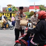 Kapolres Ngawi, AKBP Dwiasi Wiyatputera saat membagikan paket makanan kepada pengguna jalan, Jumat (24/2/2023)