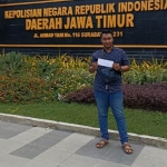 Andri Yulianto di depan kantor Polda Jatim menunjukkan bukti tanda terima pengaduannya.