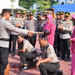 Kapolres Gresik, AKBP Rovan Richard Mahenu beserta istri menyiram air bertabur bunga kepada Aiptu Ponco Esti dan Aiptu Umar. Foto: Ist.

