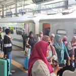 Suasana naik-turun penumpang di stasiun kereta api.