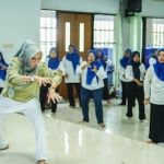 Seorang instruktur sedang mengajarkan tari tradisional.