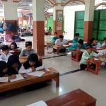 Para santri TPQ Maftakhussuluk saat belajar mengaji di Masjid SMKN 1 Tanjunganom. Foto: DEWI TALITHA N. N./ BANGSAONLINE