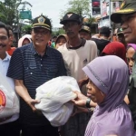 Bupati Sambari - Wabup Qosim saat memberikan bantuan korban banjir luapan Kali Lamong. foto: SYUHUD/ BANGSAONLINE