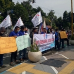 Puluhan buruh saat menggelar demo di depan kantor Disnaker Jombang.