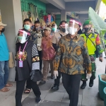 Wali Kota Risma saat mendampingi Menko PMK, Muhadjir memasuki Pasar Genteng. foto: YUDI A/ BANGSAONLINE