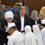 Gubernur Khofifah bersama Kepala Dindik Jatim saat menyalurkan santunan ke anak-anak.
