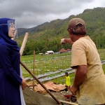 Fatihatur Rohmah saat berbincang dengan salah satu pekerja bangunan di Desa Pakis. (foto: HERMAN/ BANGSAONLINE)