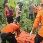 Petugas BPBD Surabaya saat mengevakuasi jasad pria misterius yang ditemukan terapung di sungai kawasan Barata Jaya