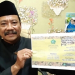 Kabag Kesra Zainul Arifin menunjukkan brosur lomba Desain Batik Jemaah Haji, Senin (14/10). foto: MUSTAIN/ BANGSAONLINE