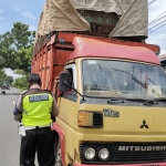 Petugas Satlantas Polres Jombang saat menghentikan salah satu truk yang kelebihan muatan. foto: AAN AMRULLOH/ BANGSAONLINE