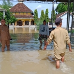 Camat Balongpanggang Muhammad Amri Maulana (kiri) memantau desa di wilayahnya yang terendam banjir. Foto: SYUHUD/ BANGSAONLINE