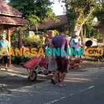 Warga RT 06 Dusun Gebangan saat membenahi jalan yang rusak di tepi kantor Desa Winong, Kecamatan Gemarang, Kabupaten Madiun. Foto: HENDRO SUHARTONO/BANGSAONLINE
